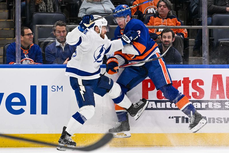 Feb 8, 2024; Elmont, New York, USA; New York Islanders defenseman Mike Reilly (2) and Tampa Bay Lightning center Tyler Motte (64) collide during the first period at UBS Arena. Mandatory Credit: Dennis Schneidler-USA TODAY Sports