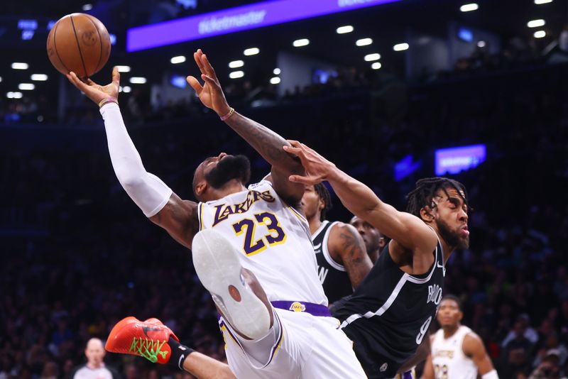 NEW YORK, NEW YORK - MARCH 31: LeBron James #23 of the Los Angeles Lakers and Trendon Watford #9 of the Brooklyn Nets collide under the basket at Barclays Center on March 31, 2024 in New York City. NOTE TO USER: User expressly acknowledges and agrees that, by downloading and or using this photograph, User is consenting to the terms and conditions of the Getty Images License Agreement. (Photo by Mike Stobe/Getty Images)