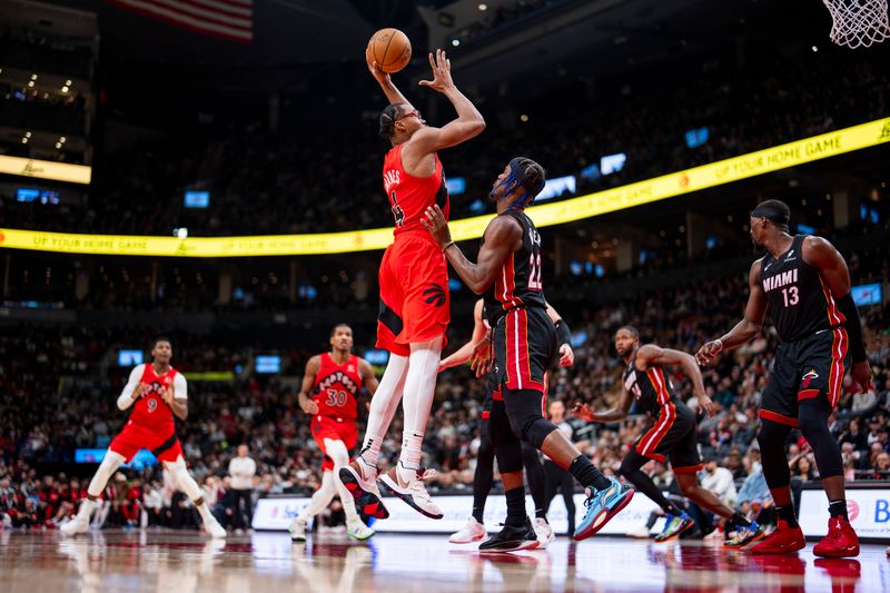 TORONTO, ON - DECEMBER 1: Scottie Barnes #4 of the Toronto Raptors shoots the ball against Jimmy Butler #22 of the Miami Heat at Scotiabank Arena on December 1, 2024 in Toronto, Ontario, Canada. NOTE TO USER: User expressly acknowledges and agrees that, by downloading and/or using this Photograph, user is consenting to the terms and conditions of the Getty Images License Agreement. (Photo by Andrew Lahodynskyj/Getty Images)