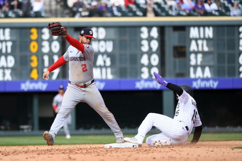 Apr 19, 2025; Denver, Colorado, USA; Colorado Rockies catcher Hunter Goodman (15) slides into second safely ahead of a play by Washington Nationals second base Luis García Jr. (2) during the seventh inning at Coors Field. Mandatory Credit: Christopher Hanewinckel-Imagn Images