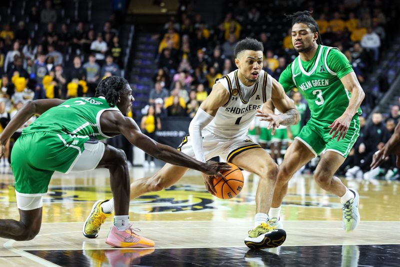 Jan 29, 2025; Wichita, Kansas, USA; Wichita State Shockers guard Xavier Bell (1) drives to the basket around North Texas Mean Green guard Jasper Floyd (3) at Charles Koch Arena. Mandatory Credit: William Purnell-Imagn Images