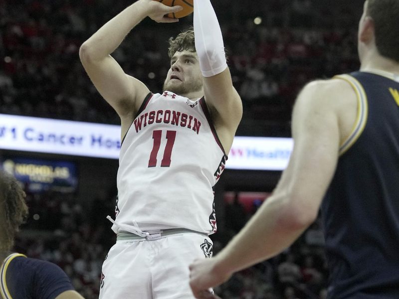 Dec 3, 2024; Madison, Wisconsin, USA; Wisconsin guard Max Klesmit (11) hits a three-point basket during the second half of their game Tuesday, December 3, 2024 at the Kohl Center in Madison, Wisconsin. Michigan beat Wisconsin 67-64.  Mandatory Credit: Mark Hoffman/USA TODAY Network via Imagn Images 