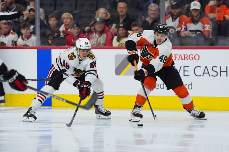 Nov 23, 2024; Philadelphia, Pennsylvania, USA; Philadelphia Flyers center Morgan Frost (48) passes the puck against Chicago Blackhawks center Teuvo Teravainen (86) in the first period at Wells Fargo Center. Mandatory Credit: Kyle Ross-Imagn Images