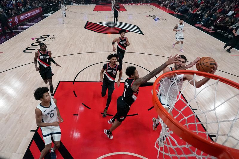 PORTLAND, OREGON - NOVEMBER 10: Santi Aldama #7 of the Memphis Grizzlies drives to the basket against Anfernee Simons #1 of the Portland Trail Blazers during the first half at Moda Center on November 10, 2024 in Portland, Oregon. NOTE TO USER: User expressly acknowledges and agrees that, by downloading and or using this photograph, User is consenting to the terms and conditions of the Getty Images License Agreement. (Photo by Soobum Im/Getty Images)