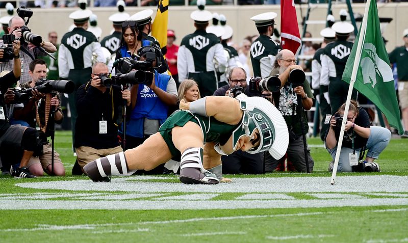 Sep 16, 2023; East Lansing, Michigan, USA; Michigan State Spartans mascot Sparty does one-handed pushups for photographers before the game against the Washington Huskies at Spartan Stadium. Mandatory Credit: Dale Young-USA TODAY Sports