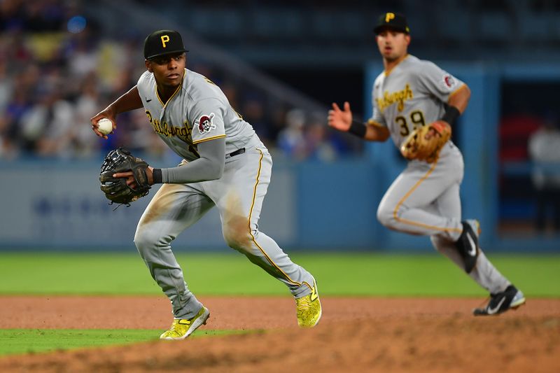 Jul 6, 2023; Los Angeles, California, USA; Pittsburgh Pirates second baseman Rodolfo Castro (14) throws to first for the out against Los Angeles Dodgers catcher Austin Barnes (15) during the fifth inning at Dodger Stadium. Mandatory Credit: Gary A. Vasquez-USA TODAY Sports