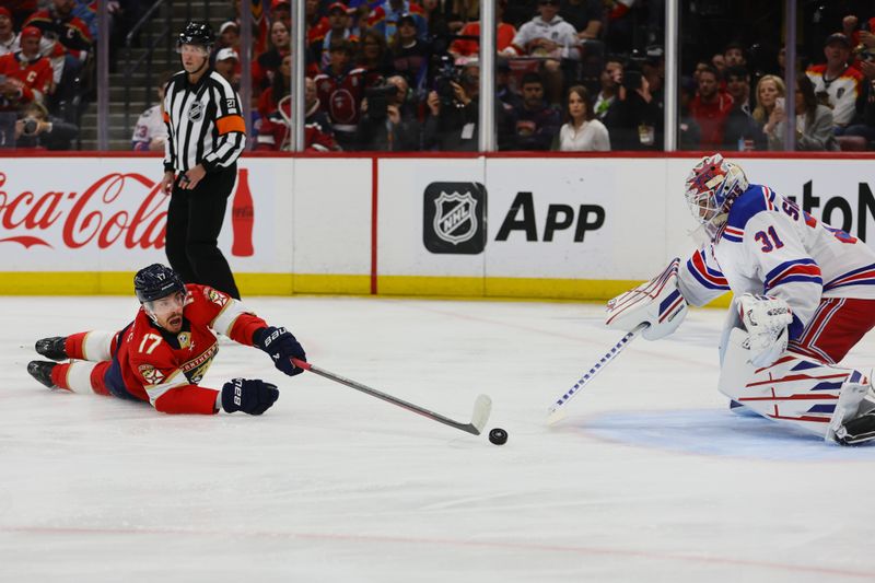 May 26, 2024; Sunrise, Florida, USA; Florida Panthers center Evan Rodrigues (17) dives for the puck against New York Rangers goaltender Igor Shesterkin (31) during the first period in game three of the Eastern Conference Final of the 2024 Stanley Cup Playoffs at Amerant Bank Arena. Mandatory Credit: Sam Navarro-USA TODAY Sports