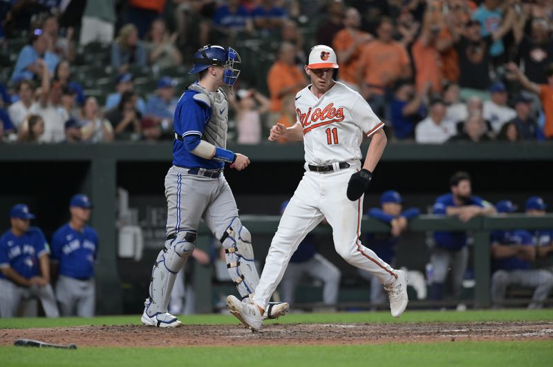 Aug 23, 2023; Baltimore, Maryland, USA;  Baltimore Orioles second baseman Jordan Westburg (11) scores in front of Toronto Blue Jays catcher Danny Jansen (9) during the eighth inning at Oriole Park at Camden Yards. Mandatory Credit: Tommy Gilligan-USA TODAY Sports