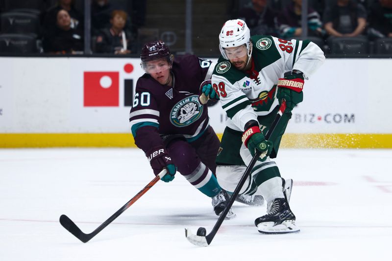 Mar 19, 2024; Anaheim, California, USA; Minnesota Wild center Frederick Gaudreau (89) skates with the puck against Anaheim Ducks defenseman Jackson LaCombe (60) during the third period of a game at Honda Center. Mandatory Credit: Jessica Alcheh-USA TODAY Sports