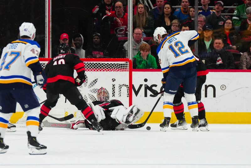 Jan 6, 2024; Raleigh, North Carolina, USA; Carolina Hurricanes goaltender Antti Raanta (32) stops the shot by St. Louis Blues right wing Kevin Hayes (12) during the first period at PNC Arena. Mandatory Credit: James Guillory-USA TODAY Sports