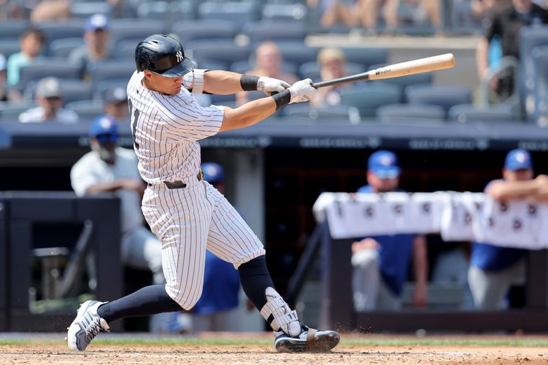 Aug 3, 2024; Bronx, New York, USA; New York Yankees shortstop Anthony Volpe (11) follows through on a two run home run against the Toronto Blue Jays during the fifth inning at Yankee Stadium. Mandatory Credit: Brad Penner-USA TODAY Sports