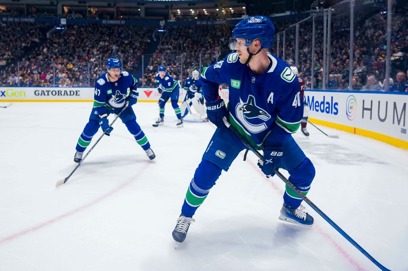 Mar 13, 2024; Vancouver, British Columbia, CAN; Vancouver Canucks defenseman Noah Juulsen (47) watches as forward Elias Pettersson (40) handles the puck against the Colorado Avalanche in the first period at Rogers Arena. Mandatory Credit: Bob Frid-USA TODAY Sports