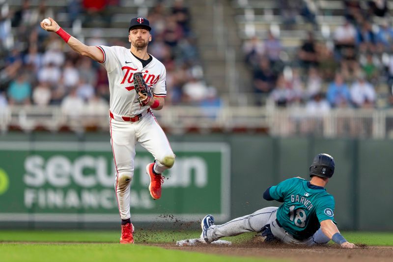 May 8, 2024; Minneapolis, Minnesota, USA; Minnesota Twins second baseman Edouard Julien (47) forces out Seattle Mariners designated hitter Mitch Garver (18) at second base and throws the ball to first base in an attempt for a double play in the sixth inning at Target Field. Mandatory Credit: Jesse Johnson-USA TODAY Sports