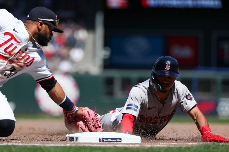 May 5, 2024; Minneapolis, Minnesota, USA; Boston Red Sox David Hamilton (70) dives back to first base as Minnesota Twins first baseman Carlos Santana (30) attempts a tag during the sixth inning at Target Field. Mandatory Credit: Matt Krohn-USA TODAY Sports