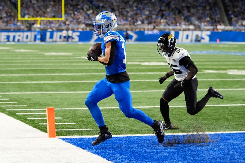 Detroit Lions wide receiver Amon-Ra St. Brown (14) catches a nine-yard touchdown pass as Jacksonville Jaguars cornerback Ronald Darby (25) defends during the second half of an NFL football game, Sunday, Nov. 17, 2024, in Detroit. (AP Photo/Carlos Osorio)