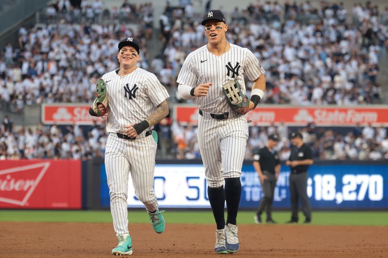 Jun 5, 2024; Bronx, New York, USA; New York Yankees left fielder Alex Verdugo (24) and center fielder Aaron Judge (99) run off the field during the second inning against the Minnesota Twins at Yankee Stadium. Mandatory Credit: Vincent Carchietta-USA TODAY Sports