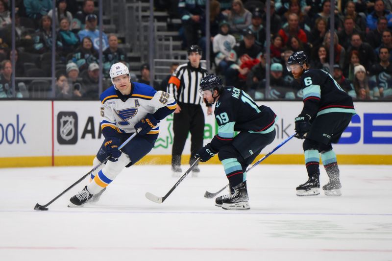 Jan 26, 2024; Seattle, Washington, USA; St. Louis Blues defenseman Colton Parayko (55) plays the puck while defended by Seattle Kraken left wing Jared McCann (19) during overtime at Climate Pledge Arena. Mandatory Credit: Steven Bisig-USA TODAY Sports