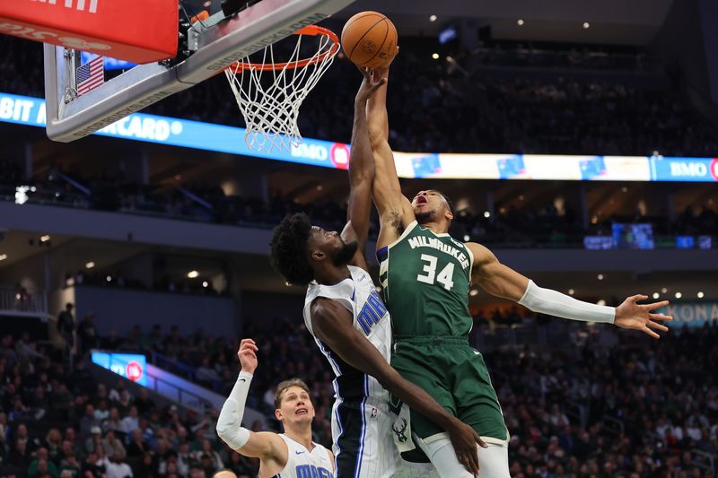 MILWAUKEE, WISCONSIN - DECEMBER 21: Giannis Antetokounmpo #34 of the Milwaukee Bucks is fouled by Jonathan Isaac #1 of the Orlando Magic during the first half of a game at Fiserv Forum on December 21, 2023 in Milwaukee, Wisconsin. NOTE TO USER: User expressly acknowledges and agrees that, by downloading and or using this photograph, User is consenting to the terms and conditions of the Getty Images License Agreement. (Photo by Stacy Revere/Getty Images)