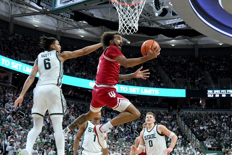 Jan 13, 2026; East Lansing, Michigan, USA;  Indiana Hoosiers guard Tayton Conerway (6) shoots the ball past Michigan State Spartans forward Jordan Scott (6) during the first half at Jack Breslin Student Events Center. Mandatory Credit: Dale Young-Imagn Images