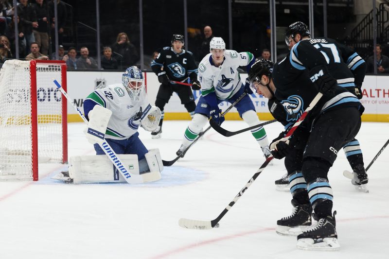 Feb 2, 2026; Salt Lake City, Utah, USA; Utah Mammoth center Nick Schmaltz (right) controls the puck against the Vancouver Canucks during the second period at Delta Center. Mandatory Credit: Rob Gray-Imagn Images