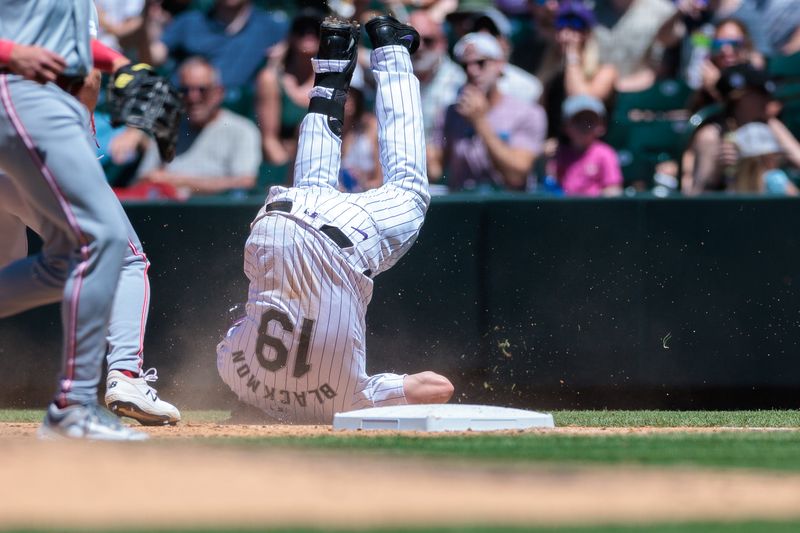 Jun 5, 2024; Denver, Colorado, USA; Colorado Rockies outfielder Charlie Blackmon (19) dives safely into first during the fourth inning against the Cincinnati Reds at Coors Field. Mandatory Credit: Andrew Wevers-USA TODAY Sports