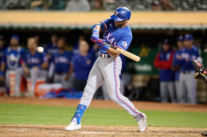 Aug 7, 2023; Oakland, California, USA; Texas Rangers outfielder Leody Taveras (3) hits an RBI sacrifice fly against the Oakland Athletics during the eighth inning at Oakland-Alameda County Coliseum. Mandatory Credit: Robert Edwards-USA TODAY Sports