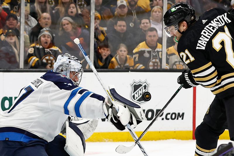 Jan 22, 2024; Boston, Massachusetts, USA; Winnipeg Jets goaltender Connor Hellebuyck (37) and Boston Bruins left wing James van Riemsdyk (21) both go for a loose puck during the second period at TD Garden. Mandatory Credit: Winslow Townson-USA TODAY Sports