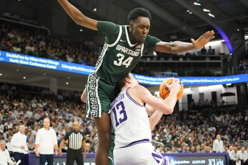 Jan 7, 2024; Evanston, Illinois, USA; Michigan State Spartans forward Xavier Booker (34) defends Northwestern Wildcats guard Brooks Barnhizer (13) during the second half at Welsh-Ryan Arena. Mandatory Credit: David Banks-USA TODAY Sports