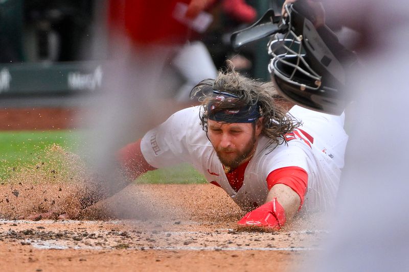 May 25, 2025; St. Louis, Missouri, USA;  St. Louis Cardinals second baseman Brendan Donovan (33) slides in safe at home against the Arizona Diamondbacks during the first inning at Busch Stadium. Mandatory Credit: Jeff Curry-Imagn Images