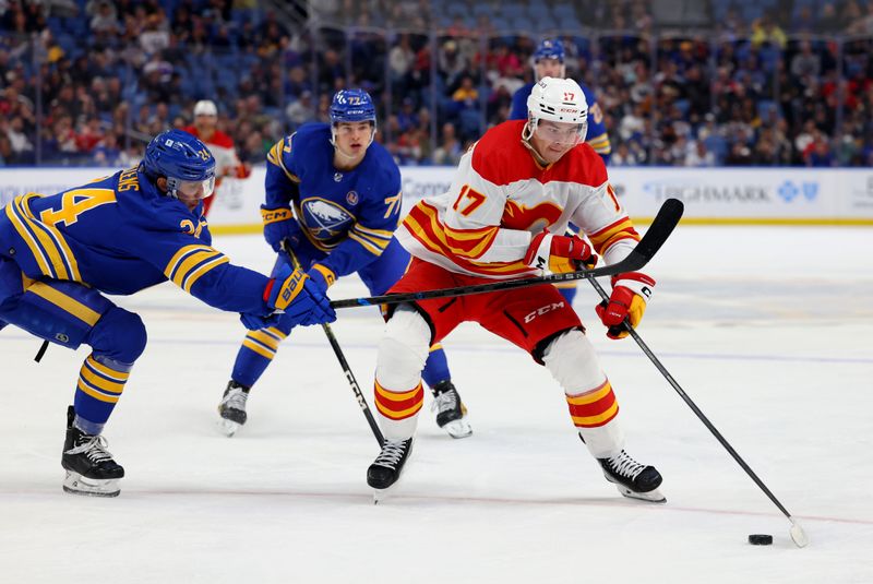 Oct 19, 2023; Buffalo, New York, USA;  Calgary Flames center Yegor Sharangovich (17) looks to make a pass as Buffalo Sabres center Dylan Cozens (24) defends during the third period at KeyBank Center. Mandatory Credit: Timothy T. Ludwig-USA TODAY Sports