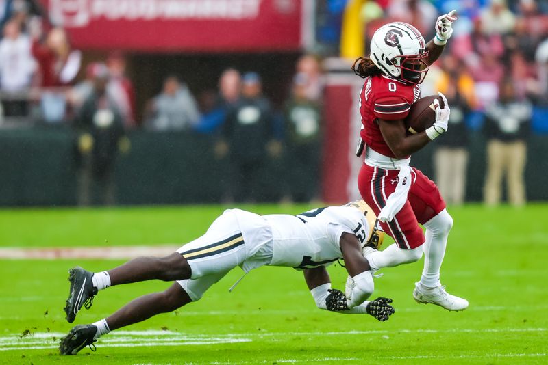 Nov 11, 2023; Columbia, South Carolina, USA; South Carolina Gamecocks running back Juju McDowell (0) runs around Vanderbilt Commodores linebacker Jeffrey Ugochukwu (12)  in the first quarter at Williams-Brice Stadium. Mandatory Credit: Jeff Blake-USA TODAY Sports