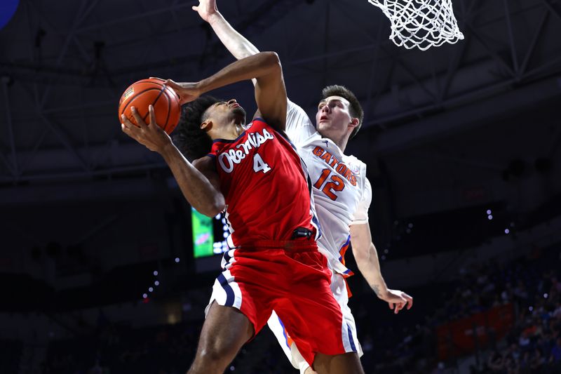 Feb 15, 2023; Gainesville, Florida, USA;    Florida Gators forward Colin Castleton  (12) defends Mississippi Rebels forward Jaemyn Brakefield (4) during the first half at Exactech Arena at the Stephen C. O'Connell Center. Mandatory Credit: Kim Klement-USA TODAY Sports