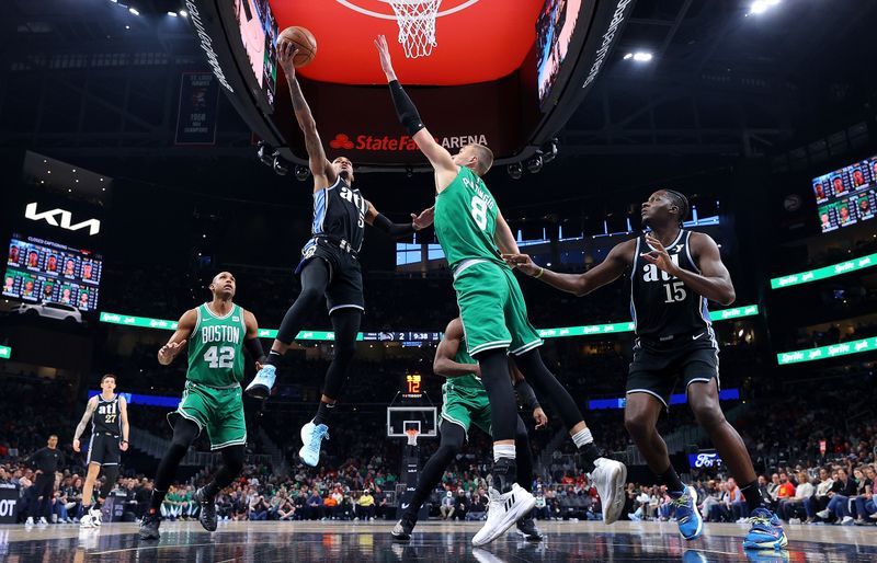 ATLANTA, GEORGIA - MARCH 25:  Dejounte Murray #5 of the Atlanta Hawks drives against Kristaps Porzingis #8 of the Boston Celtics during the first quarter at State Farm Arena on March 25, 2024 in Atlanta, Georgia.  NOTE TO USER: User expressly acknowledges and agrees that, by downloading and/or using this photograph, user is consenting to the terms and conditions of the Getty Images License Agreement. (Photo by Kevin C. Cox/Getty Images)