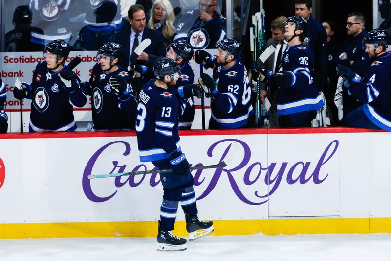 Oct 30, 2025; Winnipeg, Manitoba, CAN;  Winnipeg Jets forward Gabriel Vilardi (13) is congratulated by teammates for scoring against Chicago Blackhawks goalie Spencer Knight (30) during the first period at Canada Life Centre. Mandatory Credit: Terrence Lee-Imagn Images