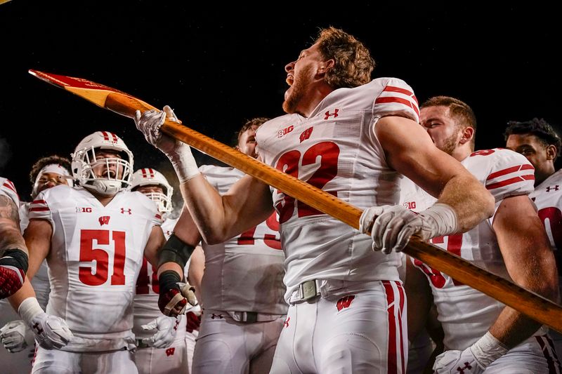 Nov 25, 2023; Minneapolis, Minnesota, USA; Wisconsin Badgers linebacker Marty Strey (32) screams after pretending to chop  down the Minnesota Golden Gophers goal post with Paul Bunyan s Axe to celebrate following a 28-14 victory to claim the rivalry trophy at Huntington Bank Stadium. Mandatory Credit: Nick Wosika-USA TODAY Sports