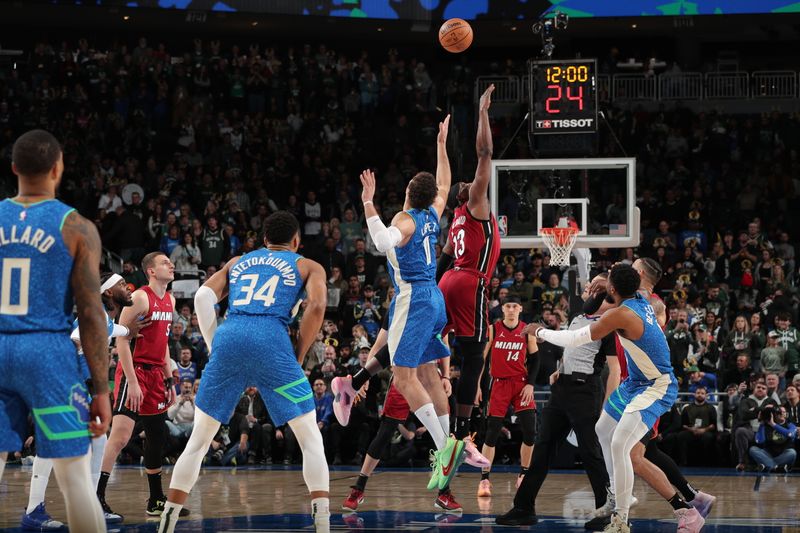 MILWAUKEE, WI - FEBRUARY 13: Brook Lopez #11 of the Milwaukee Bucks and Bam Adebayo #13 of the Miami Heat go for the opening tip-off on February 13, 2024 at the Fiserv Forum Center in Milwaukee, Wisconsin. NOTE TO USER: User expressly acknowledges and agrees that, by downloading and or using this Photograph, user is consenting to the terms and conditions of the Getty Images License Agreement. Mandatory Copyright Notice: Copyright 2024 NBAE (Photo by Gary Dineen/NBAE via Getty Images).