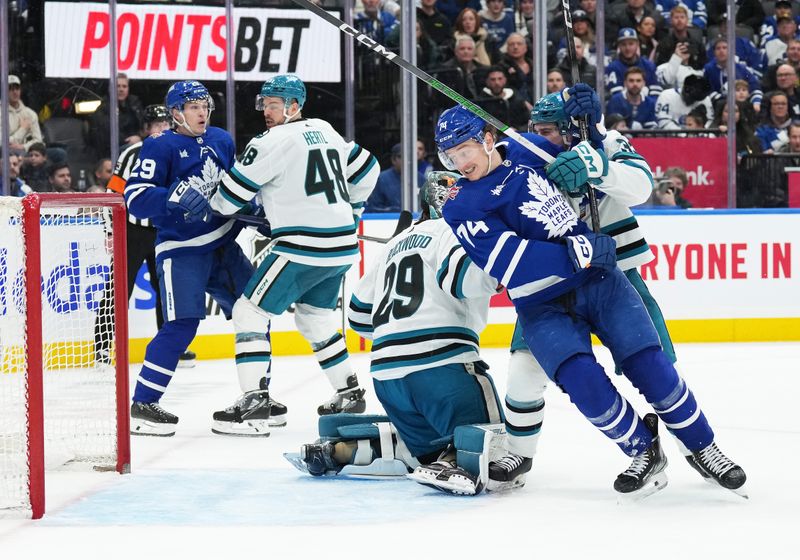 Jan 9, 2024; Toronto, Ontario, CAN; Toronto Maple Leafs center Bobby McMann (74) battles with San Jose Sharks defenseman Calen Addison (33) in front of goaltender Mackenzie Blackwood (29) during the third period at Scotiabank Arena. Mandatory Credit: Nick Turchiaro-USA TODAY Sports