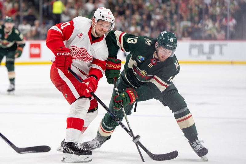 Feb 25, 2025; Saint Paul, Minnesota, USA; Detroit Red Wings right wing Vladimir Tarasenko (11) and Minnesota Wild center Yakov Trenin (13) play the puck in the first period at Xcel Energy Center. Mandatory Credit: Matt Blewett-Imagn Images