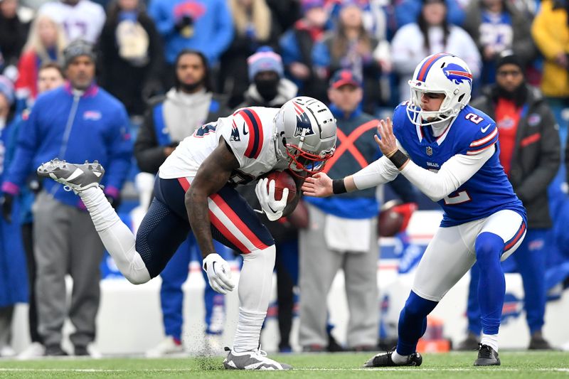 New England Patriots Jalen Reagor, left, gets past Buffalo Bills place kicker Tyler Bass (2) on a 98-yard kickoff return for a touchdown during the first half of an NFL football game in Orchard Park, N.Y., Sunday, Dec. 31, 2023. (AP Photo/Adrian Kraus)