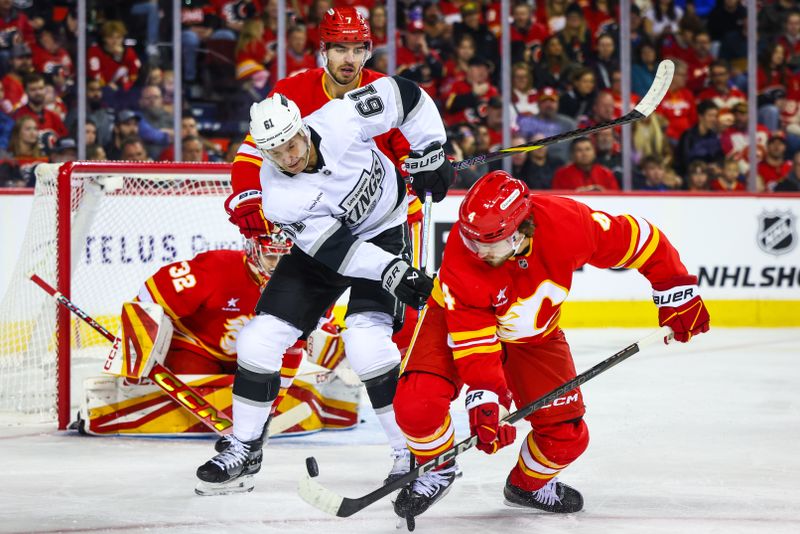 Nov 11, 2024; Calgary, Alberta, CAN; Los Angeles Kings center Trevor Lewis (61) and Calgary Flames defenseman Rasmus Andersson (4) battles for the puck in front of Calgary Flames goaltender Dustin Wolf (32) during the first period at Scotiabank Saddledome. Mandatory Credit: Sergei Belski-Imagn Images