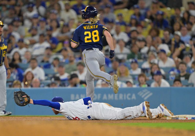 Aug 16, 2023; Los Angeles, California, USA;  Milwaukee Brewers center fielder Joey Wiemer (28) is out at first as Los Angeles Dodgers first baseman Freddie Freeman (5) reaches for a wide throw by third baseman Max Muncy (13) in the fifth inning at Dodger Stadium. Mandatory Credit: Jayne Kamin-Oncea-USA TODAY Sports