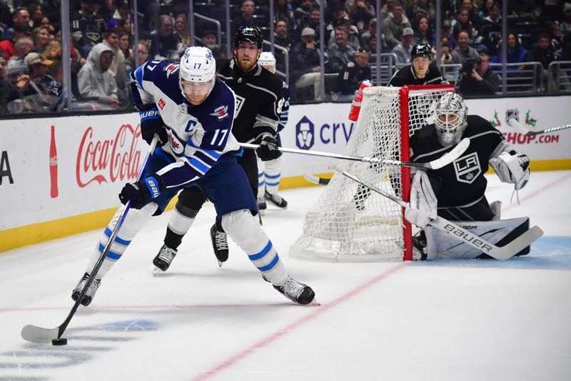 Dec 13, 2023; Los Angeles, California, USA; Winnipeg Jets center Adam Lowry (17) moves the puck against Los Angeles Kings center Pierre-Luc Dubois (80) and goaltender Cam Talbot (39) during the first period at Crypto.com Arena. Mandatory Credit: Gary A. Vasquez-USA TODAY Sports