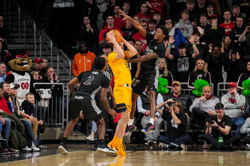 Feb 5, 2026; Cincinnati, Ohio, USA;  West Virginia Mountaineers guard Treysen Eaglestaff (52) controls the ball against Cincinnati Bearcats guard Jizzle James (2) and guard Sencire Harris (5) in the second half at Fifth Third Arena. Mandatory Credit: Aaron Doster-Imagn Images