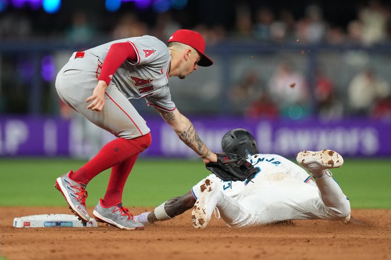 Apr 2, 2024; Miami, Florida, USA; Miami Marlins center fielder Jazz Chisholm Jr. (2) dives around the tag of Los Angeles Angels shortstop Zach Neto (9) to avoid a double play in the ninth inning at loan Depot Park. Mandatory Credit: Jim Rassol-USA TODAY Sports
