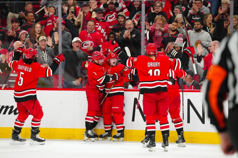 Oct 15, 2024; Raleigh, North Carolina, USA;  Carolina Hurricanes right wing Jackson Blake (53) celebrates his goal with Carolina Hurricanes defenseman Dmitry Orlov (7) against the New Jersey Devils during the second period at PNC Arena. Mandatory Credit: James Guillory-Imagn Images