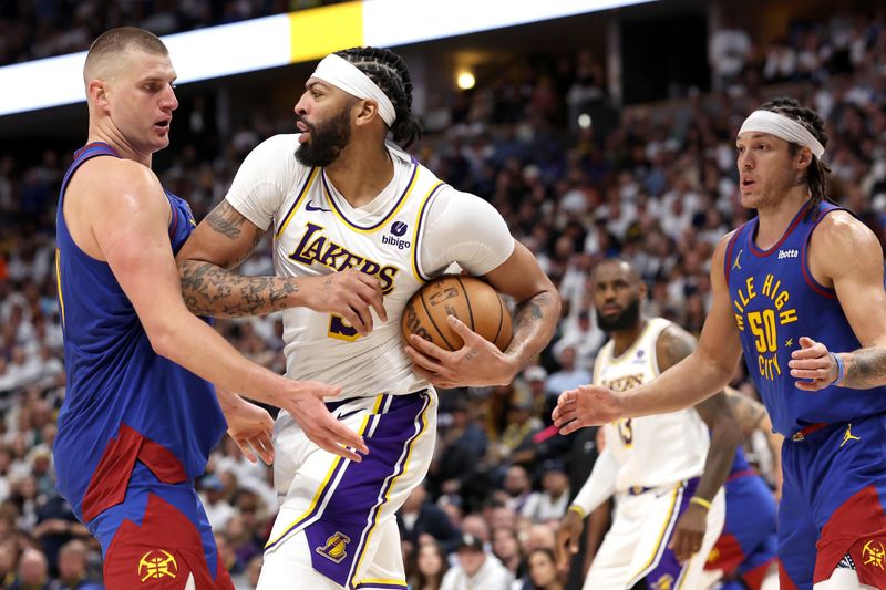 DENVER, COLORADO - APRIL 20: Nikola Jokic #15 of the Denver Nuggets fights for a rebound against Anthony Davis #3 of the Los Angeles Lakers in the fourth quarter during game one of the Western Conference First Round Playoffs at Ball Arena on April 20, 2024 in Denver, Colorado.  NOTE TO USER: User expressly acknowledges and agrees that, by downloading and or using this photograph, User is consenting to the terms and conditions of the Getty Images License Agreement. (Photo by Matthew Stockman/Getty Images)