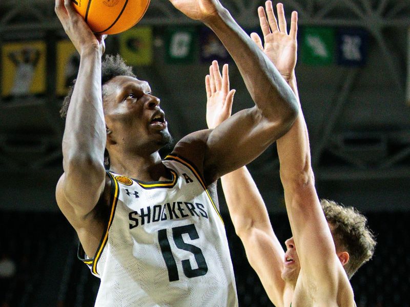 Jan 14, 2025; Wichita, Kansas, USA; Wichita State Shockers center Quincy Ballard (15) shoots over Charlotte 49ers forward Rich Rolf (24) during the second half at Charles Koch Arena. Mandatory Credit: William Purnell-Imagn Images