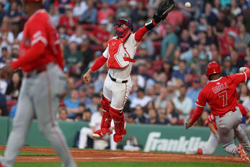 Jun 3, 2025; Boston, Massachusetts, USA; Los Angeles Angels center fielder Jo Adell (7) slides past Boston Red Sox catcher Connor Wong (12) during the third inning at Fenway Park. Mandatory Credit: Paul Rutherford-Imagn Images