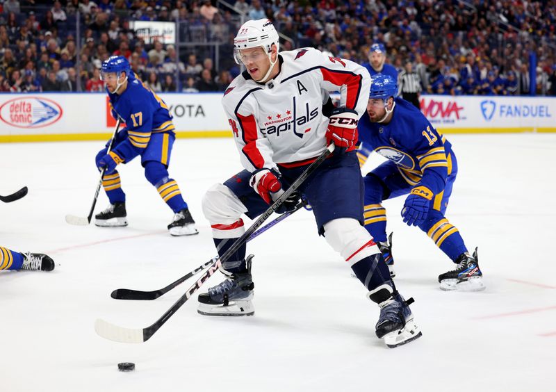 Apr 11, 2024; Buffalo, New York, USA;  Washington Capitals defenseman John Carlson (74) skates with the puck as Buffalo Sabres right wing Lukas Rousek (13) tries to defend during the first period at KeyBank Center. Mandatory Credit: Timothy T. Ludwig-USA TODAY Sports