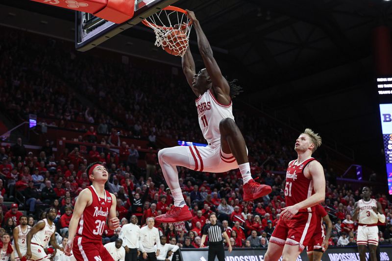 Jan 17, 2024; Piscataway, New Jersey, USA; Rutgers Scarlet Knights center Clifford Omoruyi (11) dunks the ball in front of Nebraska Cornhuskers guard Keisei Tominaga (30) and forward Rienk Mast (51) during the second half at Jersey Mike's Arena. Mandatory Credit: Vincent Carchietta-USA TODAY Sports